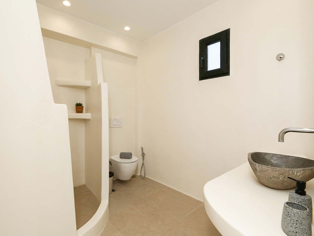 Μπάνιο της One-Bedroom Villa με πέτρινο νιπτήρα και χτιστό ντους